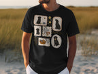 Black t-shirt with framed illustrations of black Labrador puppies playing with toys.