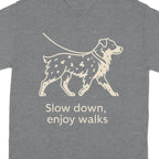Grey t-shirt with a line drawing of a dog on a leash and the text "Slow down, enjoy walks".