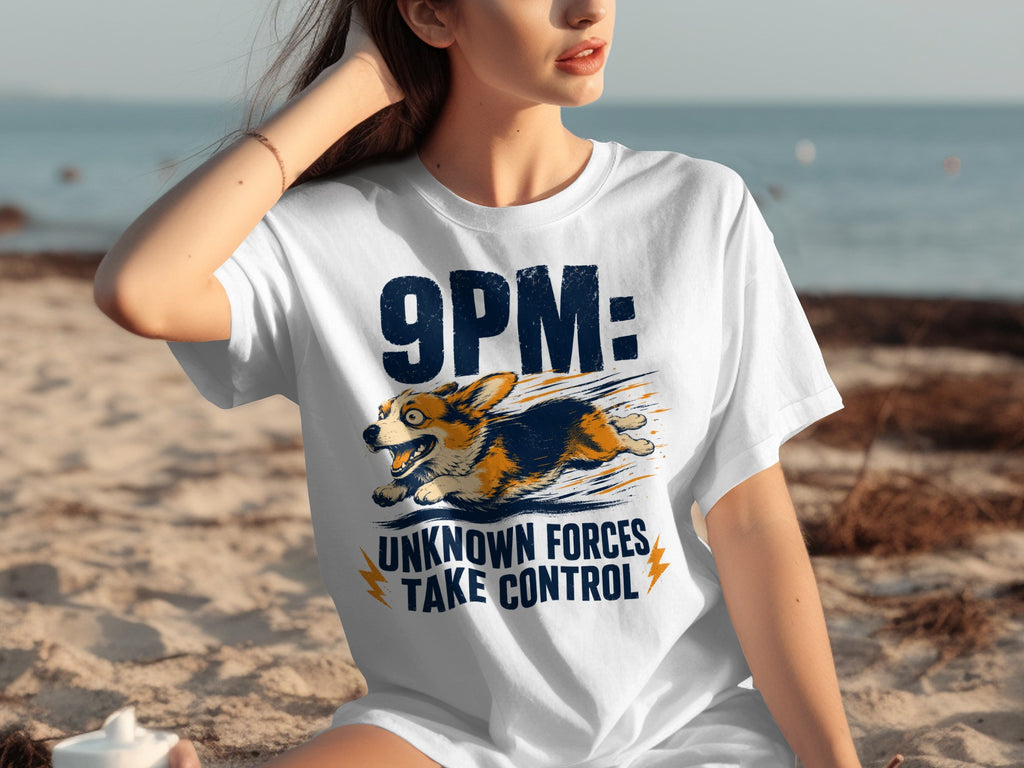 White t-shirt with "9PM: UNKNOWN FORCES TAKE CONTROL" and a running corgi.