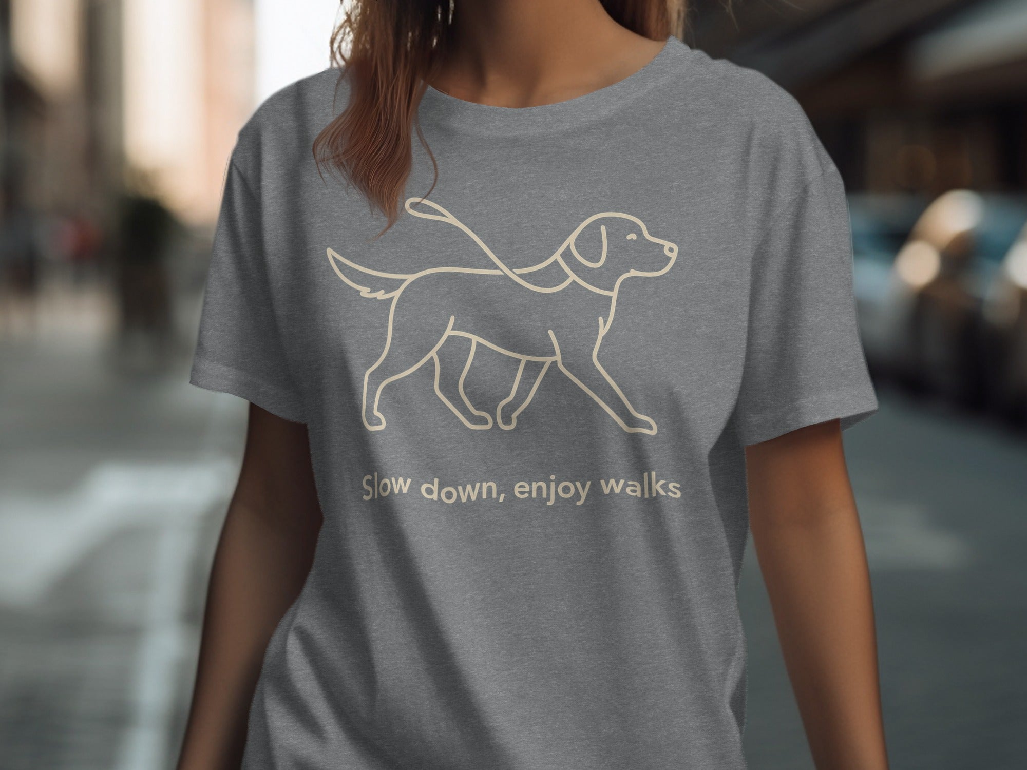 Grey t-shirt with a beige line drawing of a dog on a leash and text.