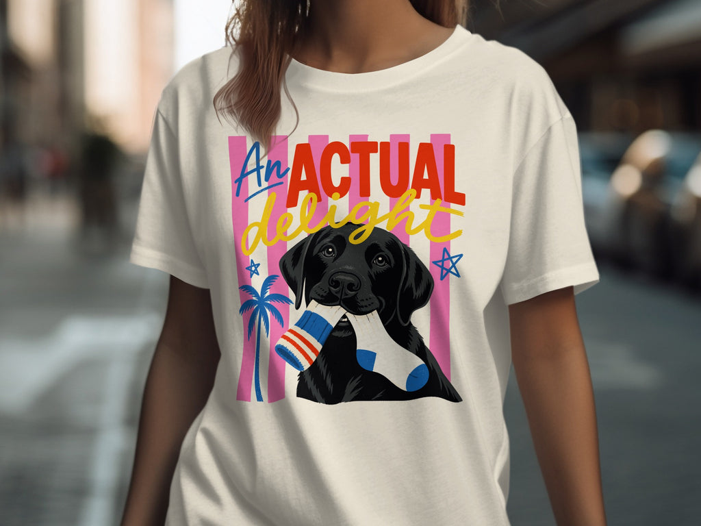 Black Labrador holding a striped sock in mouth, on t-shirt with "An Actual Delight" text.