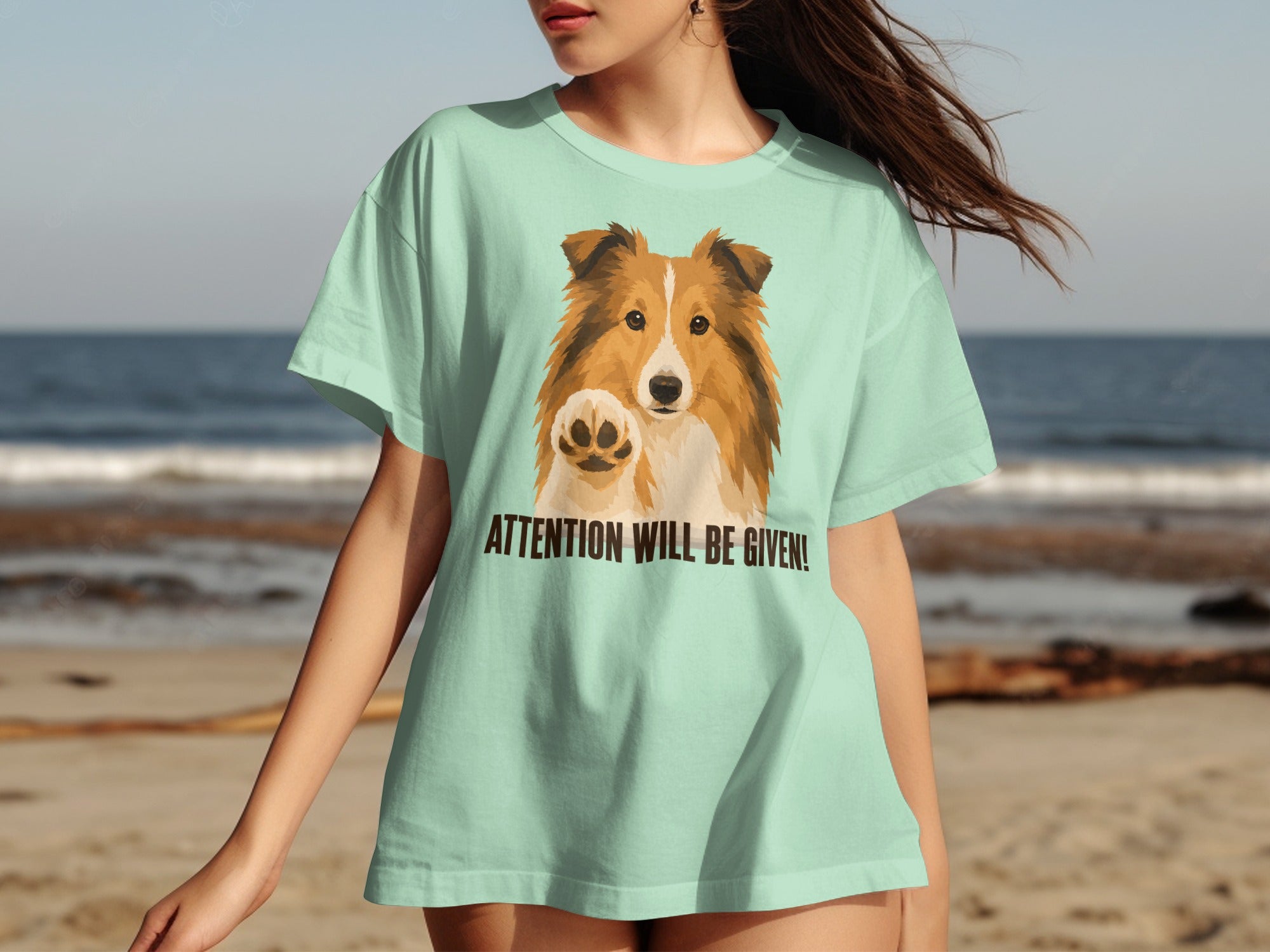 Shetland sheepdog on light green t-shirt, paw raised, "ATTENTION WILL BE GIVEN!" text.