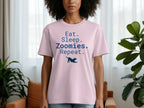 Pink t-shirt with "Eat. Sleep. Zoomies. Repeat." text and a dog silhouette.