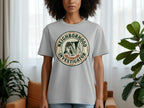 Gray t-shirt with a circular logo featuring a dog in a hat and the text "Neighborhood Investigator".
