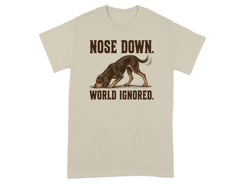 Beige t-shirt with a dog sniffing the ground and text "NOSE DOWN. WORLD IGNORED."