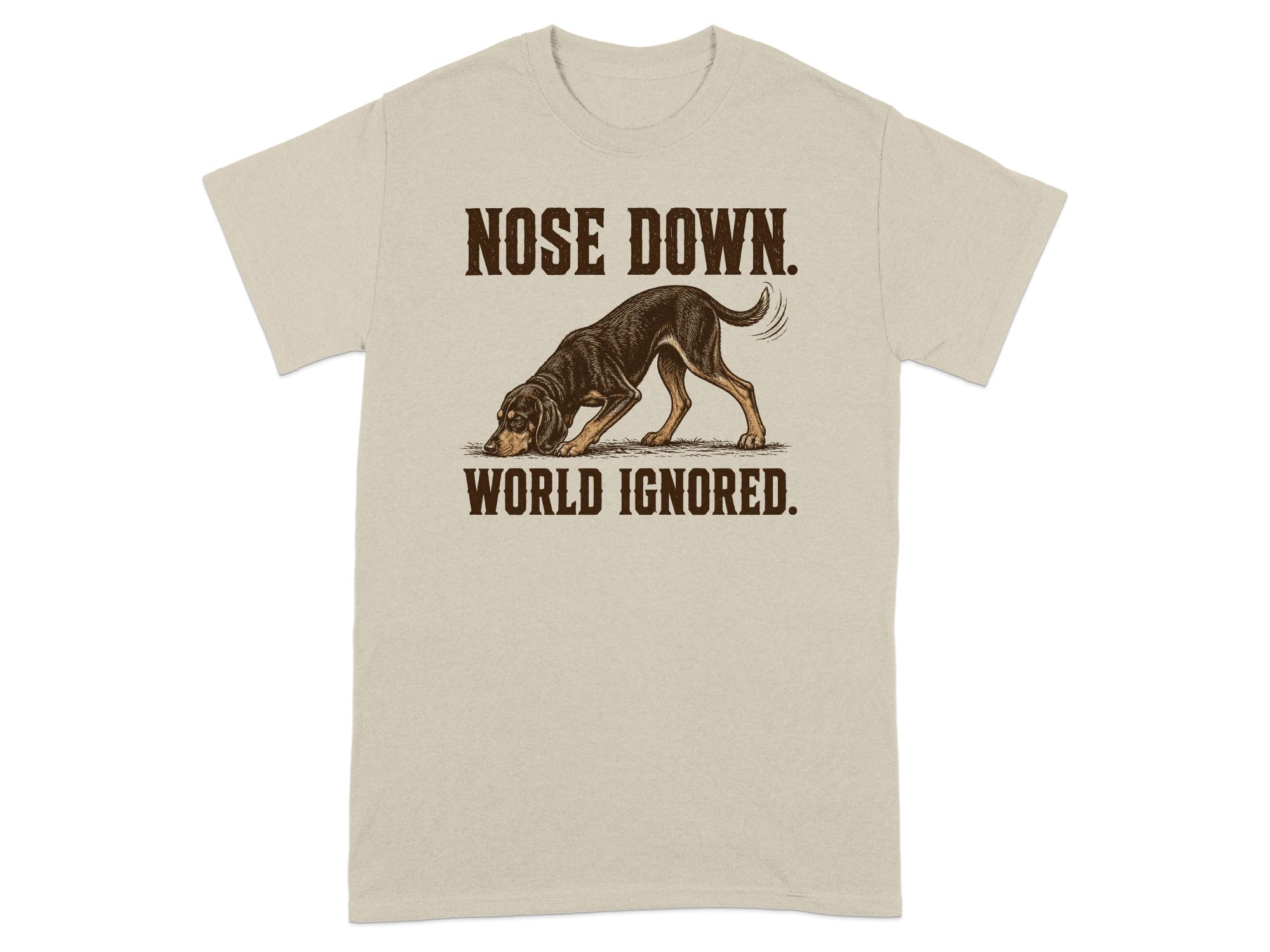 Beige t-shirt with a dog sniffing the ground and text "NOSE DOWN. WORLD IGNORED."