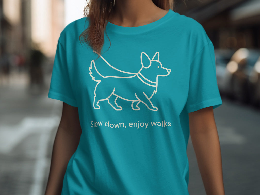 Turquoise t-shirt with white line drawing of dog and text "Slow down, enjoy walks".