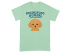 Light green t-shirt with cartoon poodle and text "OUTSMARTING HUMANS SINCE PUPPYHOOD".