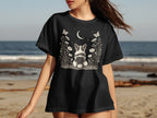 Black t-shirt with a corgi, moon, stars, flowers, and butterflies graphic.