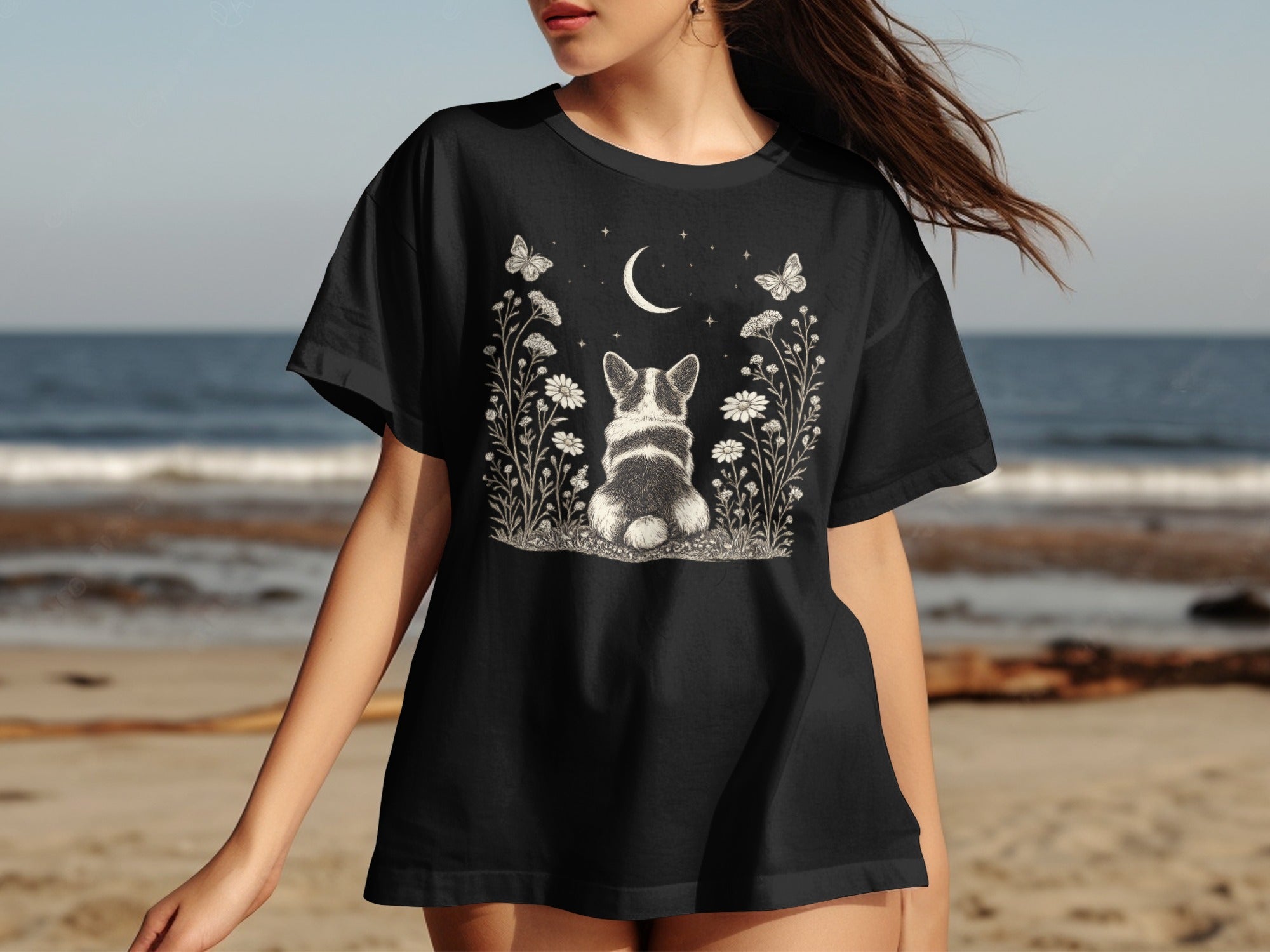 Black t-shirt with a corgi, moon, stars, flowers, and butterflies graphic.