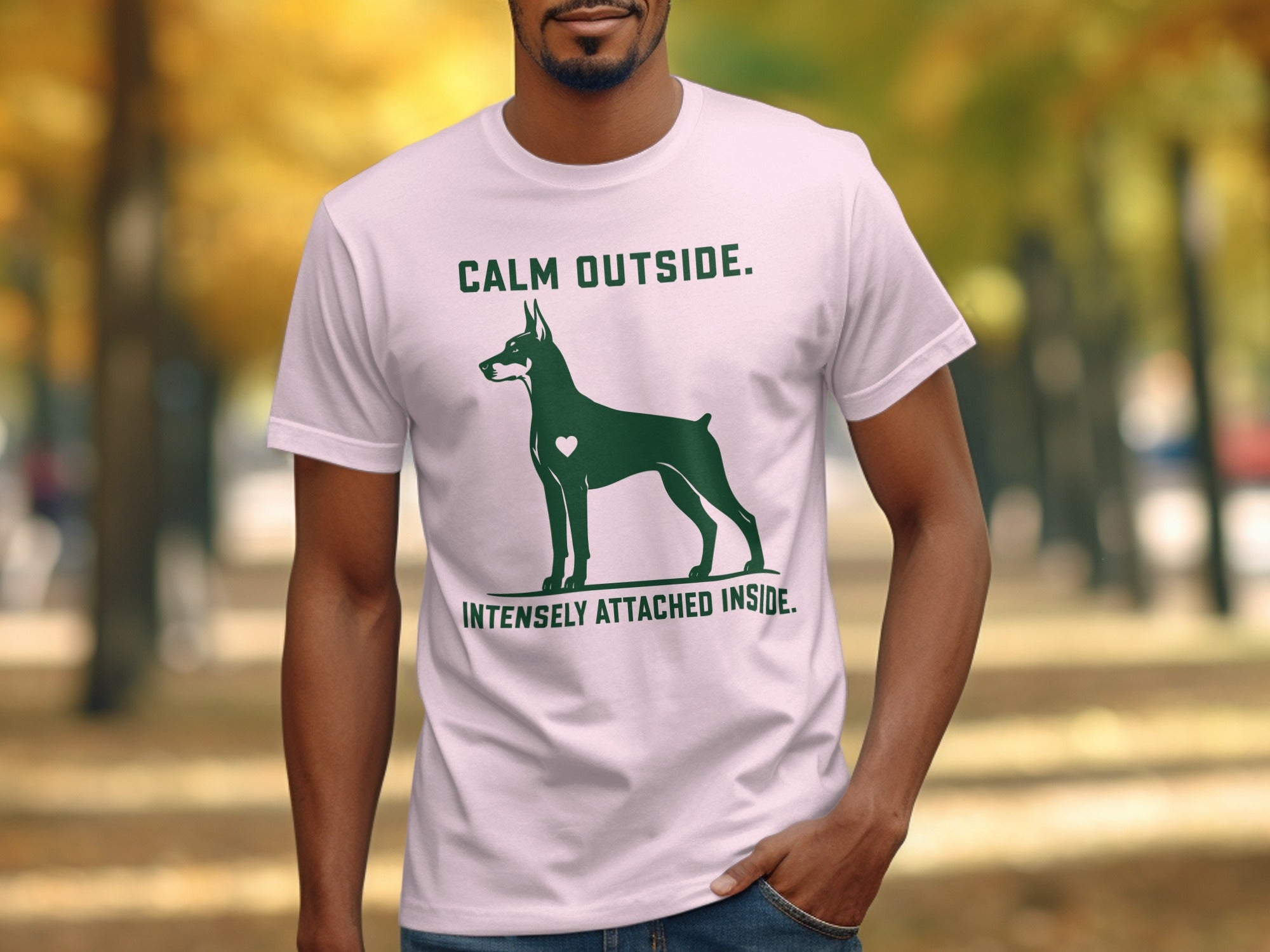 Light pink t-shirt with a Doberman silhouette and text "CALM OUTSIDE. INTENSELY ATTACHED INSIDE."