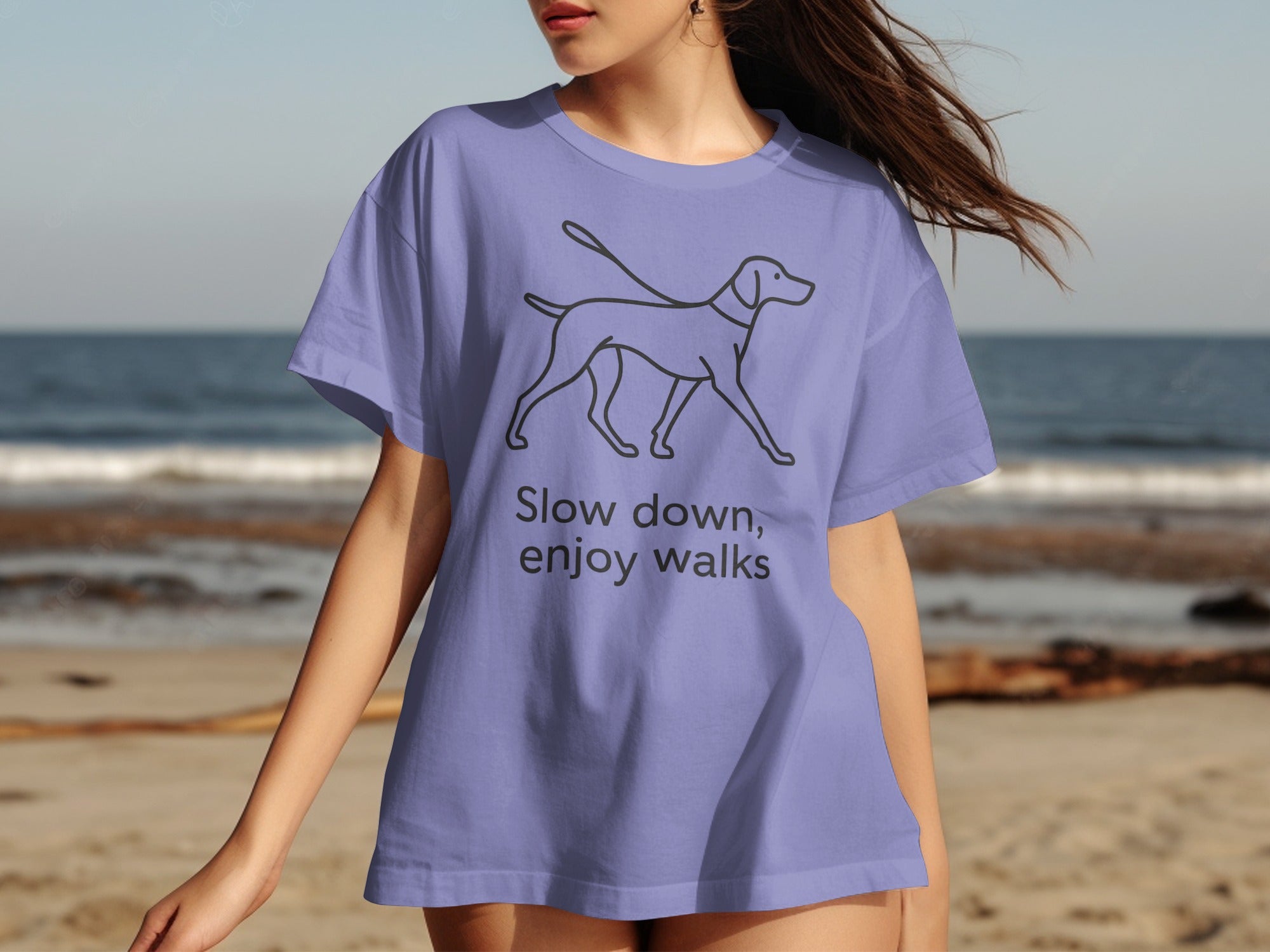 Lavender t-shirt with a line drawing of a dog and the text "Slow down, enjoy walks".