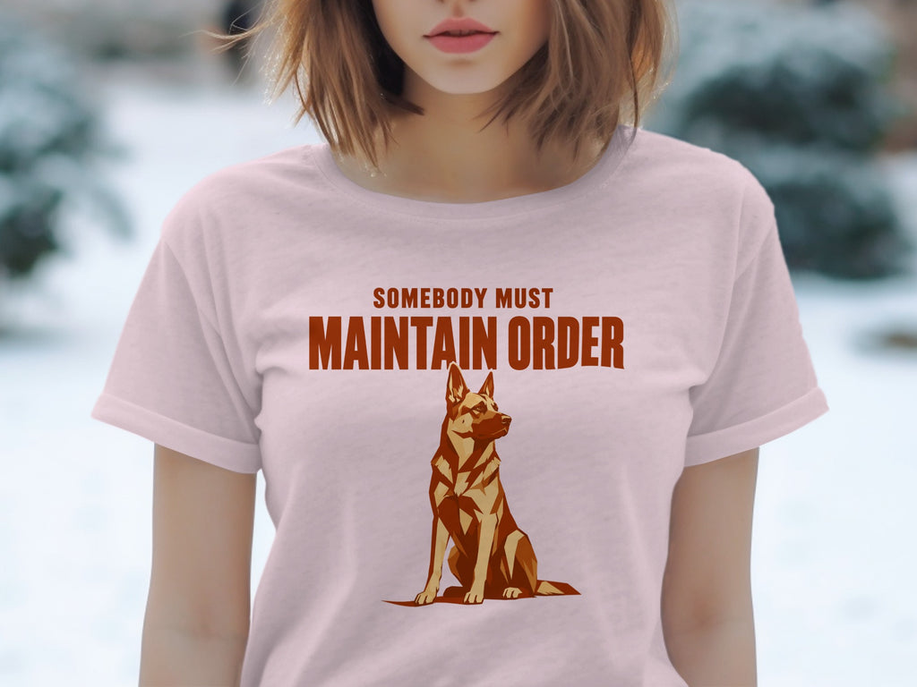Light pink t-shirt with graphic of a German Shepherd and text "Somebody Must Maintain Order."