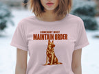 Light pink t-shirt with graphic of a German Shepherd and text "Somebody Must Maintain Order."