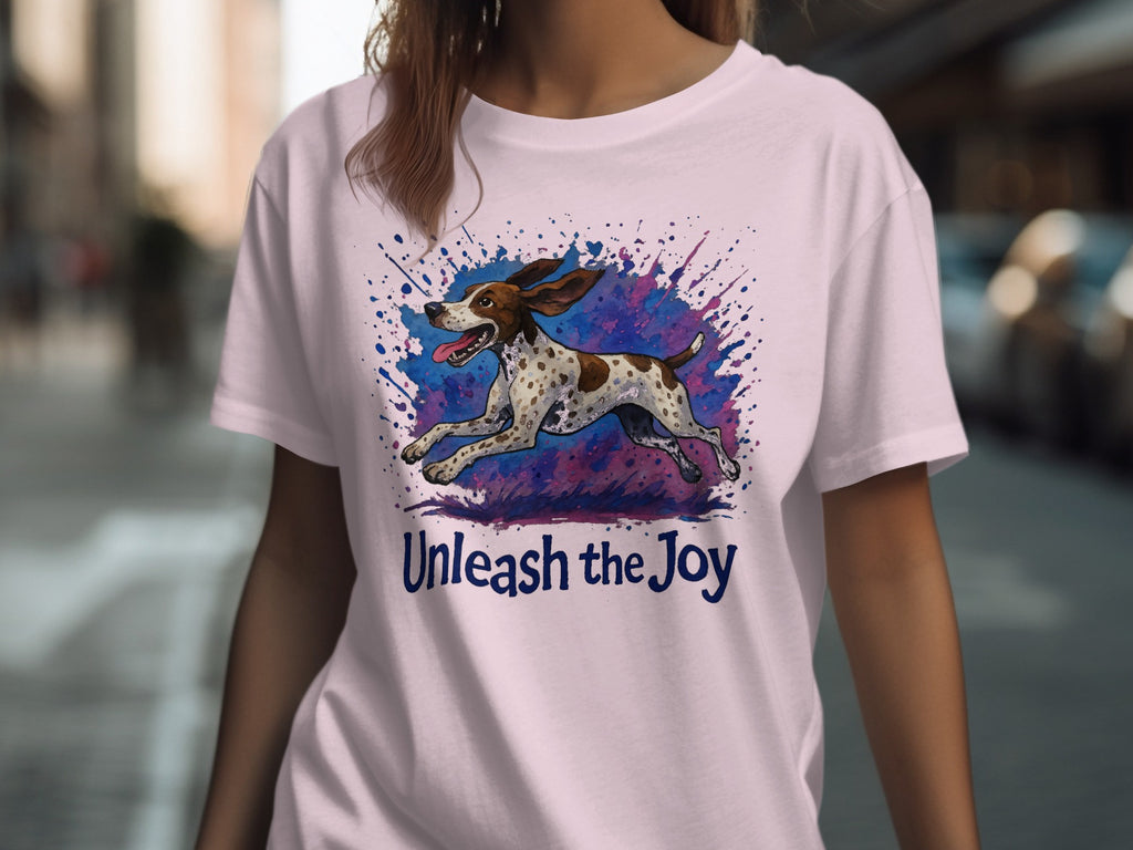 Light pink t-shirt with a running dog graphic and the text "Unleash the Joy".