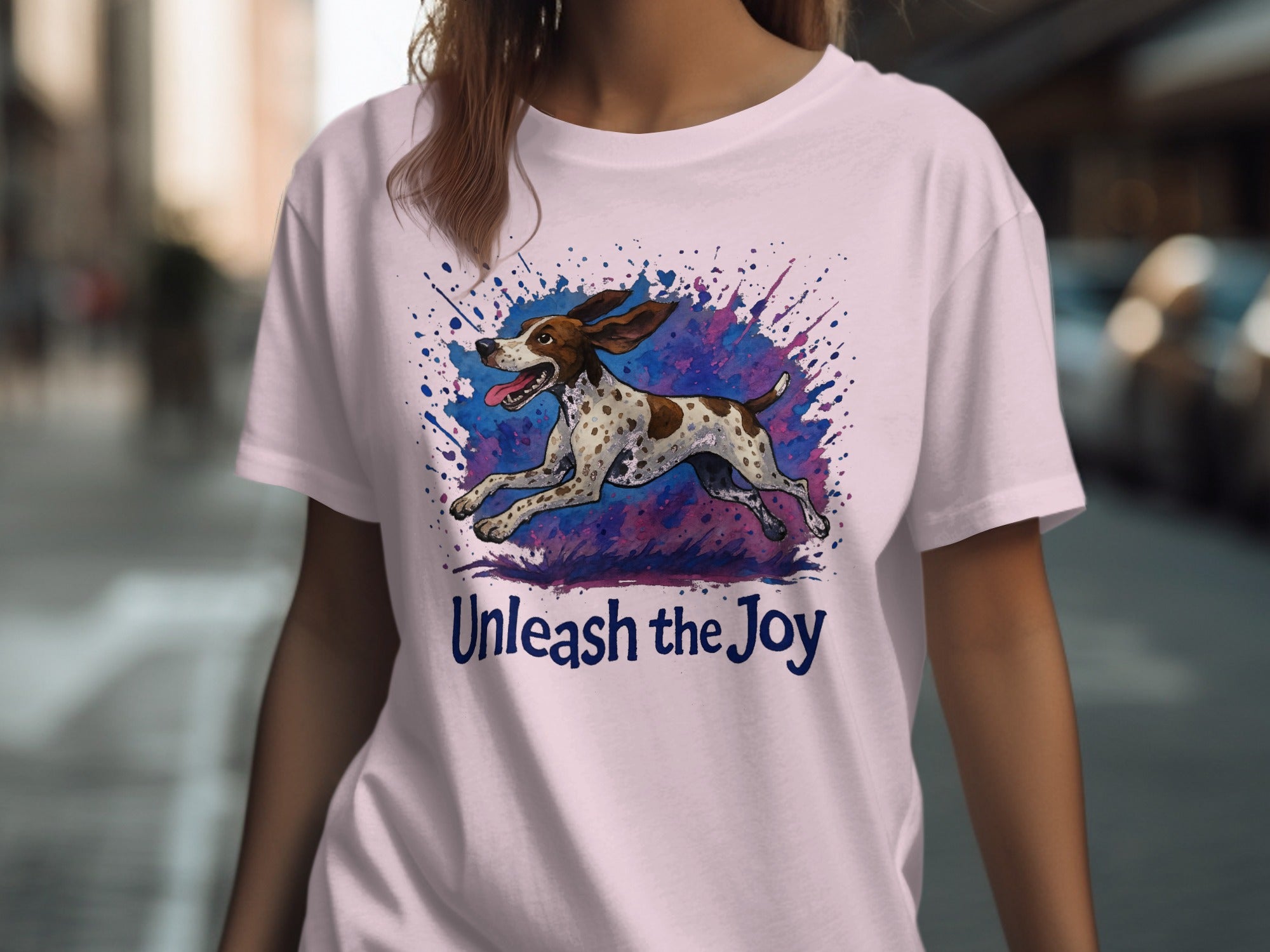 Light pink t-shirt with a running dog graphic and the text "Unleash the Joy".