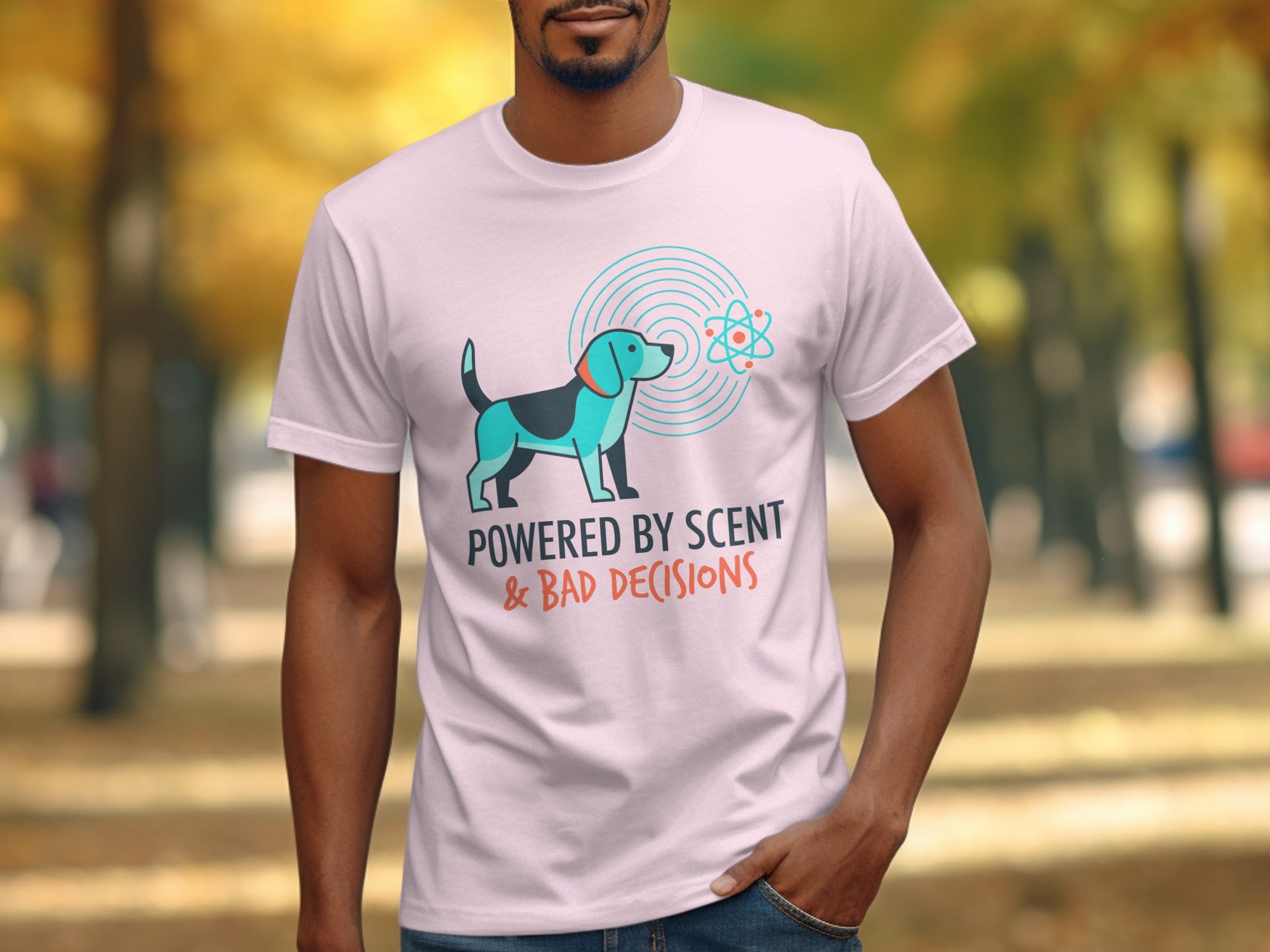 Pink t-shirt with dog and atom graphic, text "POWERED BY SCENT & BAD DECISIONS".