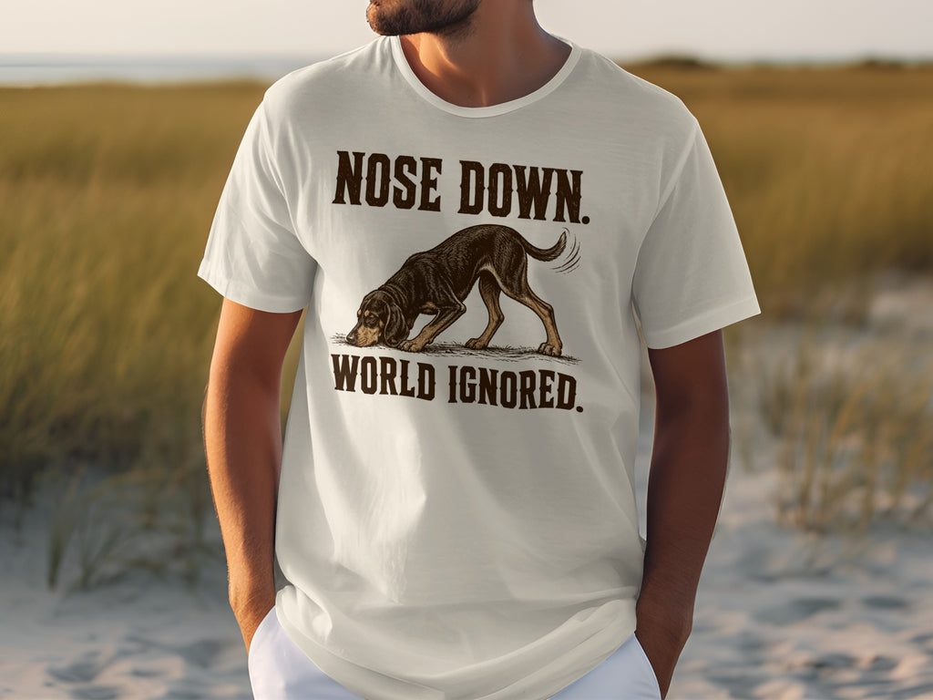 White t-shirt with graphic of a dog with "NOSE DOWN, WORLD IGNORED" text.