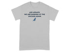 Light gray t-shirt with blue text "LIFE UPDATE: WE ARE BARKING AT THE VACUUM AGAIN" and a dog icon.