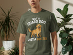 Green t-shirt with "NOT A GUARD DOG JUST A GREETER" text and golden retriever graphic.
