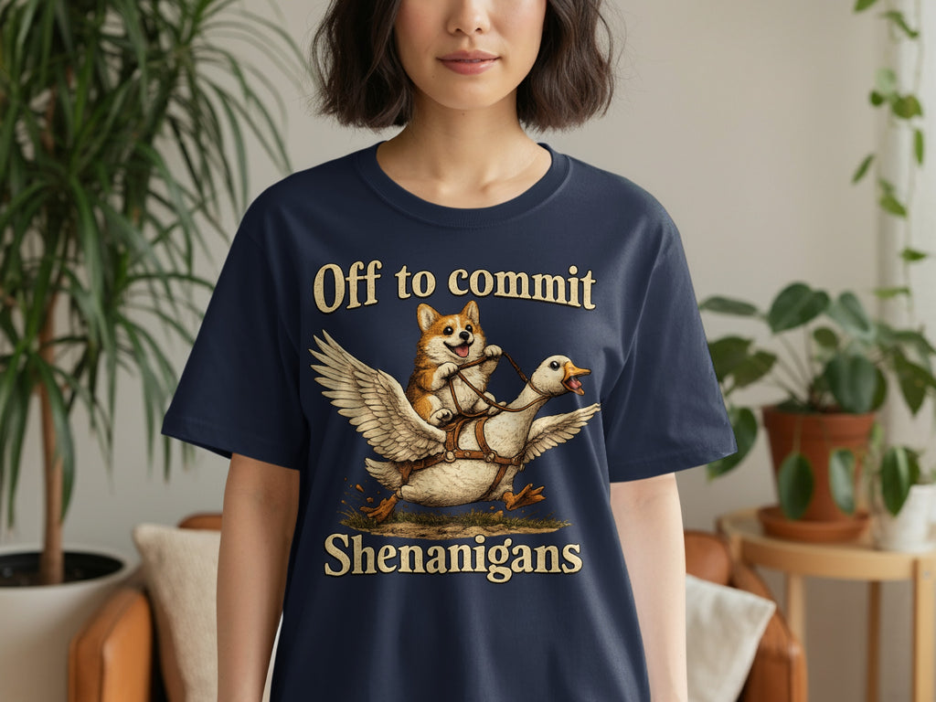 Navy t-shirt with a corgi riding a flying goose, text says "Off to commit Shenanigans".