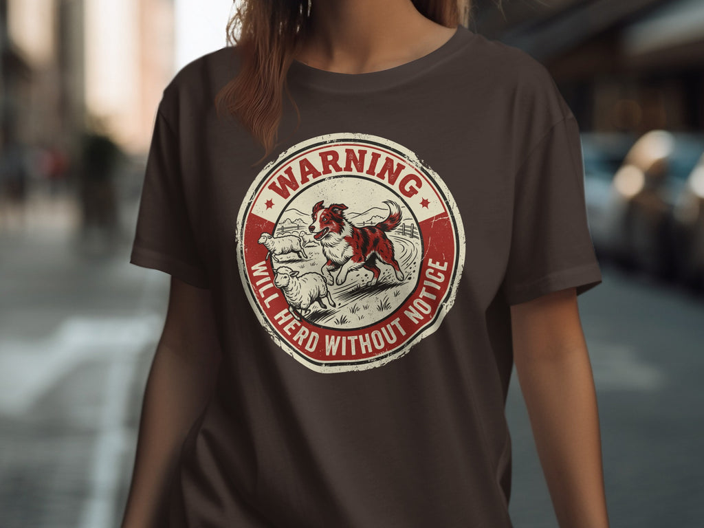 Brown t-shirt with circular "Warning Will Herd Without Notice" graphic featuring sheepdog and sheep.