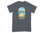 Pug sitting by water with text "Paws And Reflect" on t-shirt.