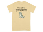 Beige t-shirt with a dog and text reading "Life update: someone walked past the house!".