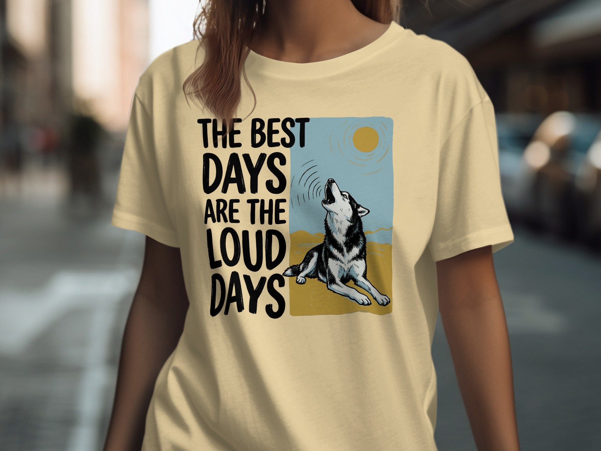 Cream t-shirt with graphic of a howling wolf and sun, with text "THE BEST DAYS ARE THE LOUD DAYS".