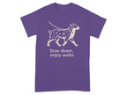 Purple t-shirt with a graphic of a dog on a leash and text "Slow down, enjoy walks."