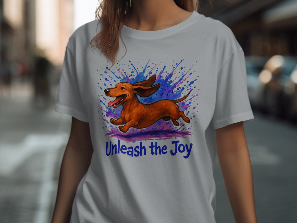 White t-shirt with brown dachshund design and "Unleash the Joy" text.