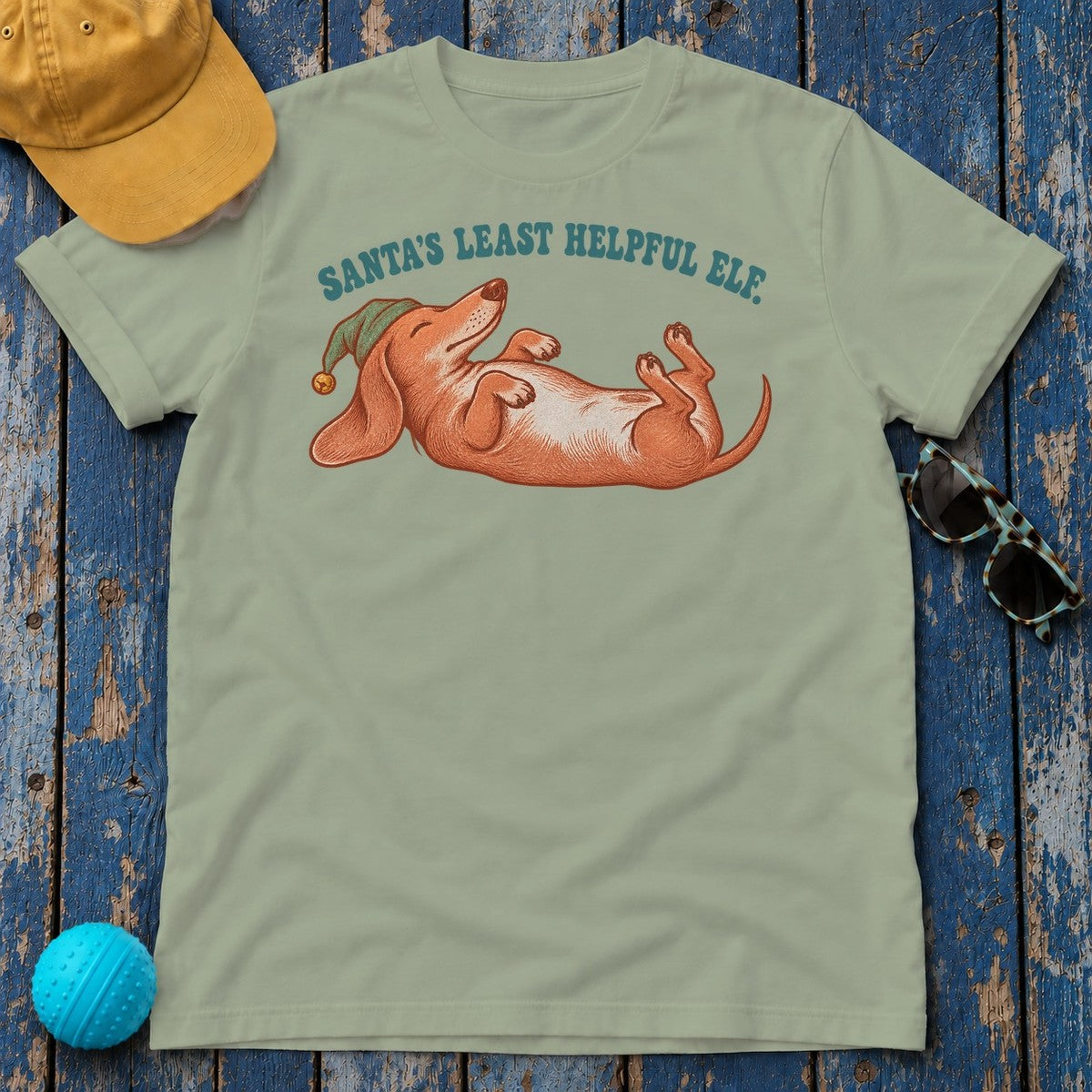 Santa's Least Helpful Elf Dachshund T-Shirt in Sage - flat lay