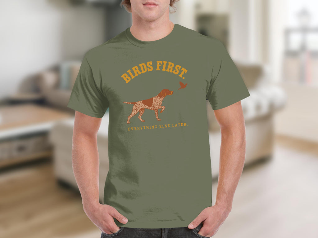 Green t-shirt with "BIRDS FIRST EVERYTHING ELSE LATER" and dog pointing at bird.