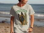 Light tan t-shirt with a dog peeking through a doorway, text reads "Personally Invested In Your Business".