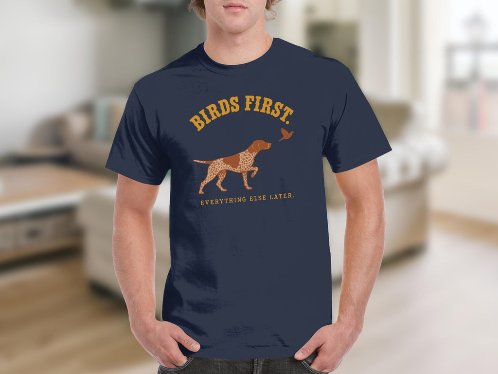Navy t-shirt with "BIRDS FIRST" and dog pointing at bird graphic.