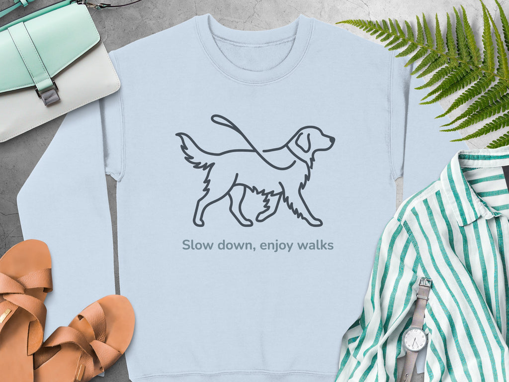 Light blue sweatshirt with a line drawing of a dog on a leash and text "Slow down, enjoy walks".