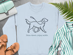 Light blue sweatshirt with a line drawing of a dog on a leash and text "Slow down, enjoy walks".