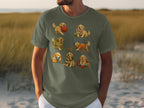 Green t-shirt featuring a collage of seven golden retriever puppies with yarn and knitting supplies.