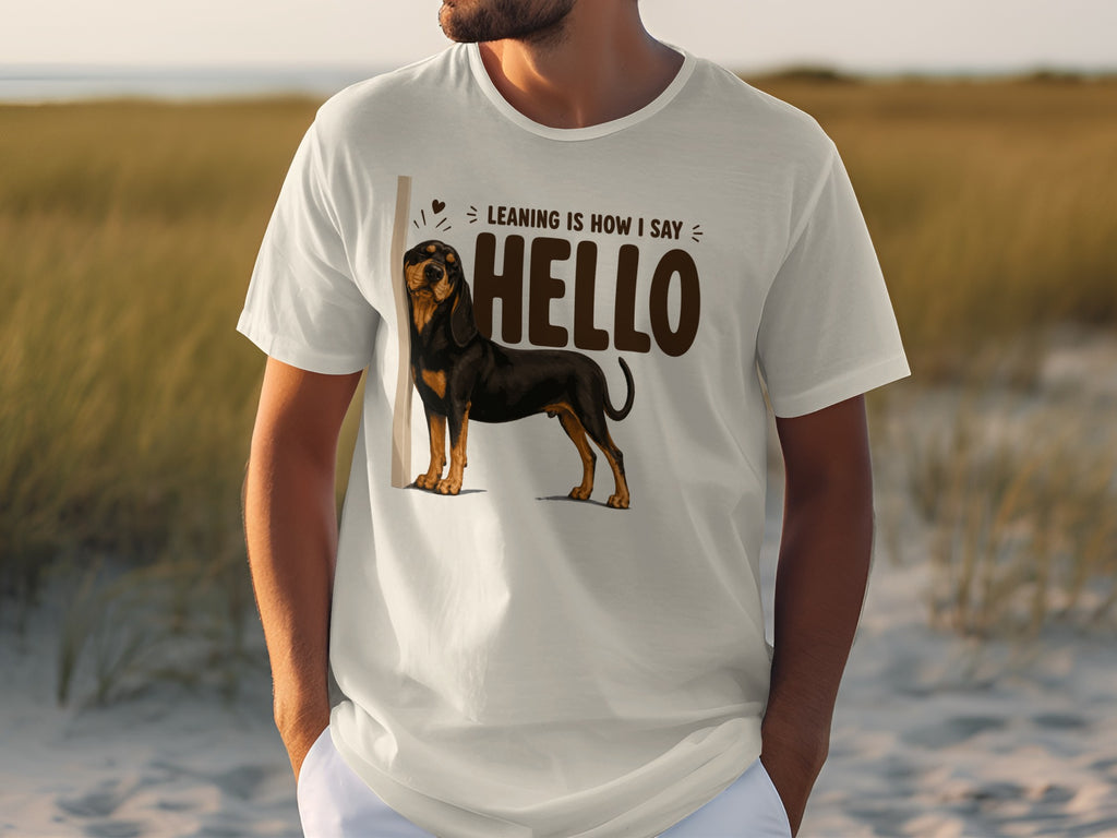 White t-shirt with graphic of a dog and text "Leaning is how I say HELLO".