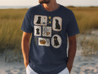 Navy t-shirt with five framed illustrations of black Labrador puppies playing.