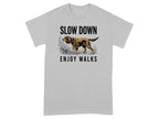 Grey t-shirt with graphic of a dog walking among grass and text "SLOW DOWN ENJOY WALKS".