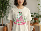 Pug wearing sunglasses rides bicycle with text "Off to cause a kerfuffle".