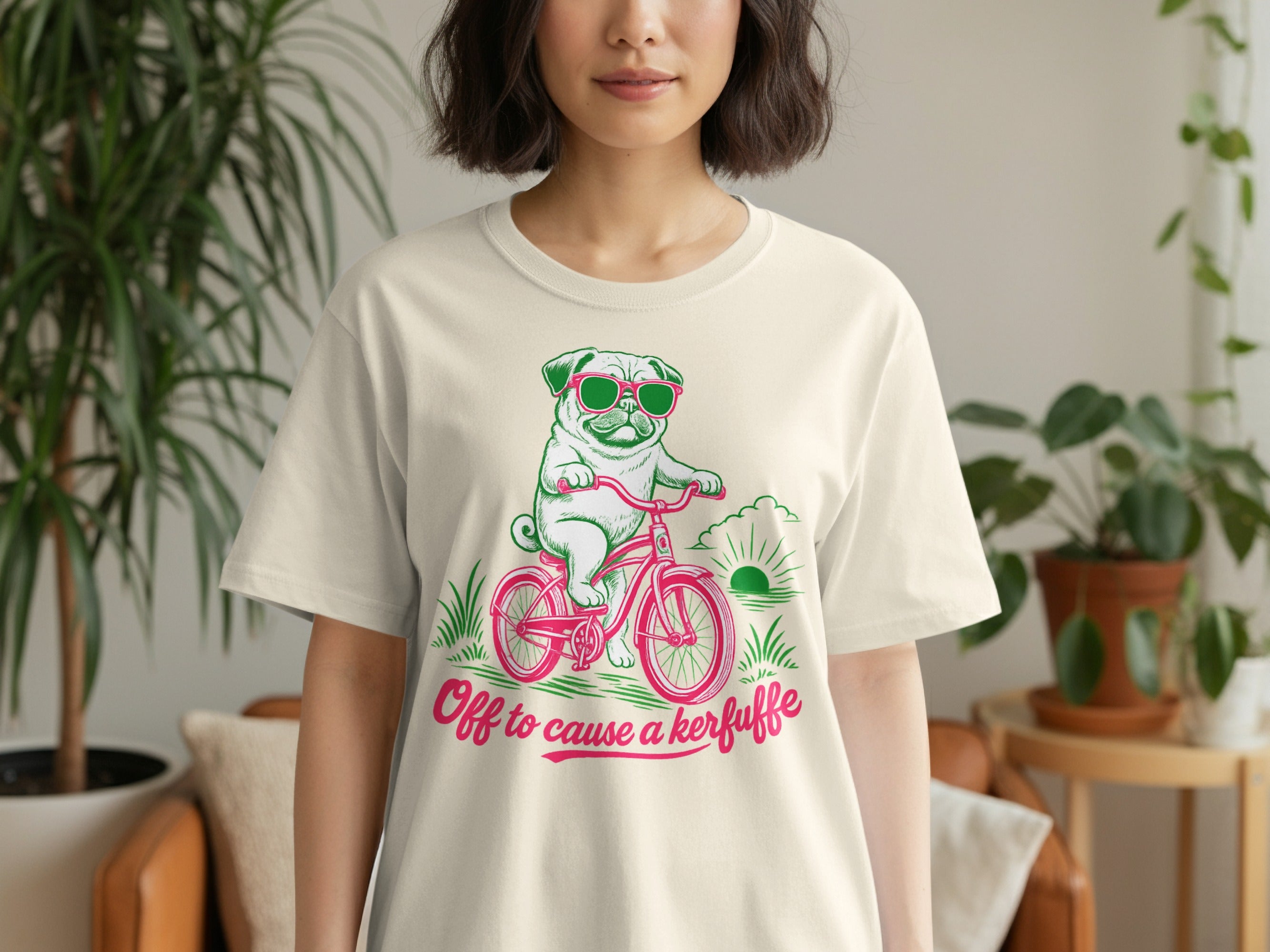 Pug wearing sunglasses rides bicycle with text "Off to cause a kerfuffle".