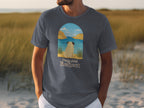 Grey t-shirt with a pug in front of an arched seascape and "Paws And Reflect" text.