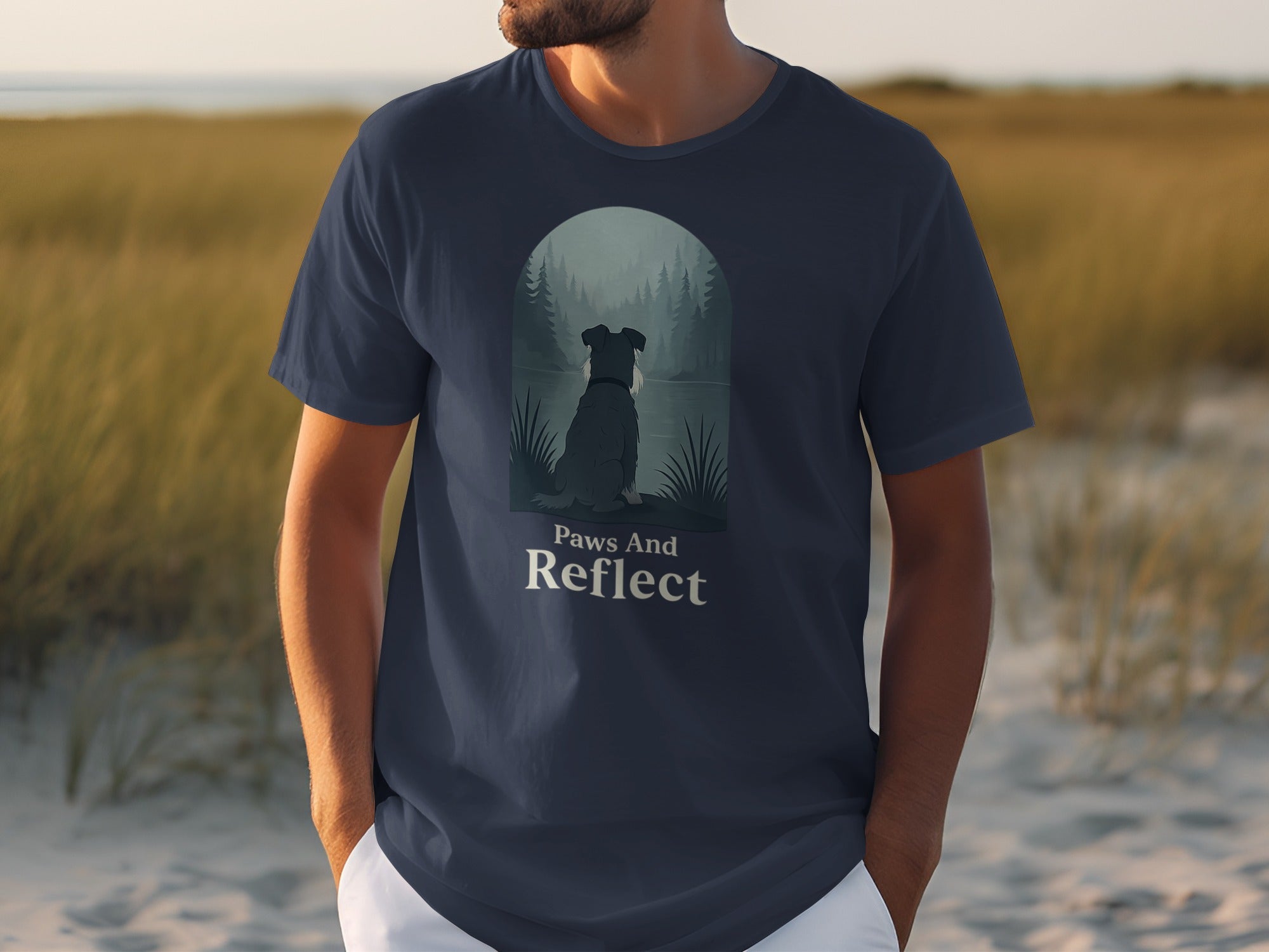 Dark navy t-shirt with illustration of dog looking at a misty forest landscape and text "Paws And Reflect".