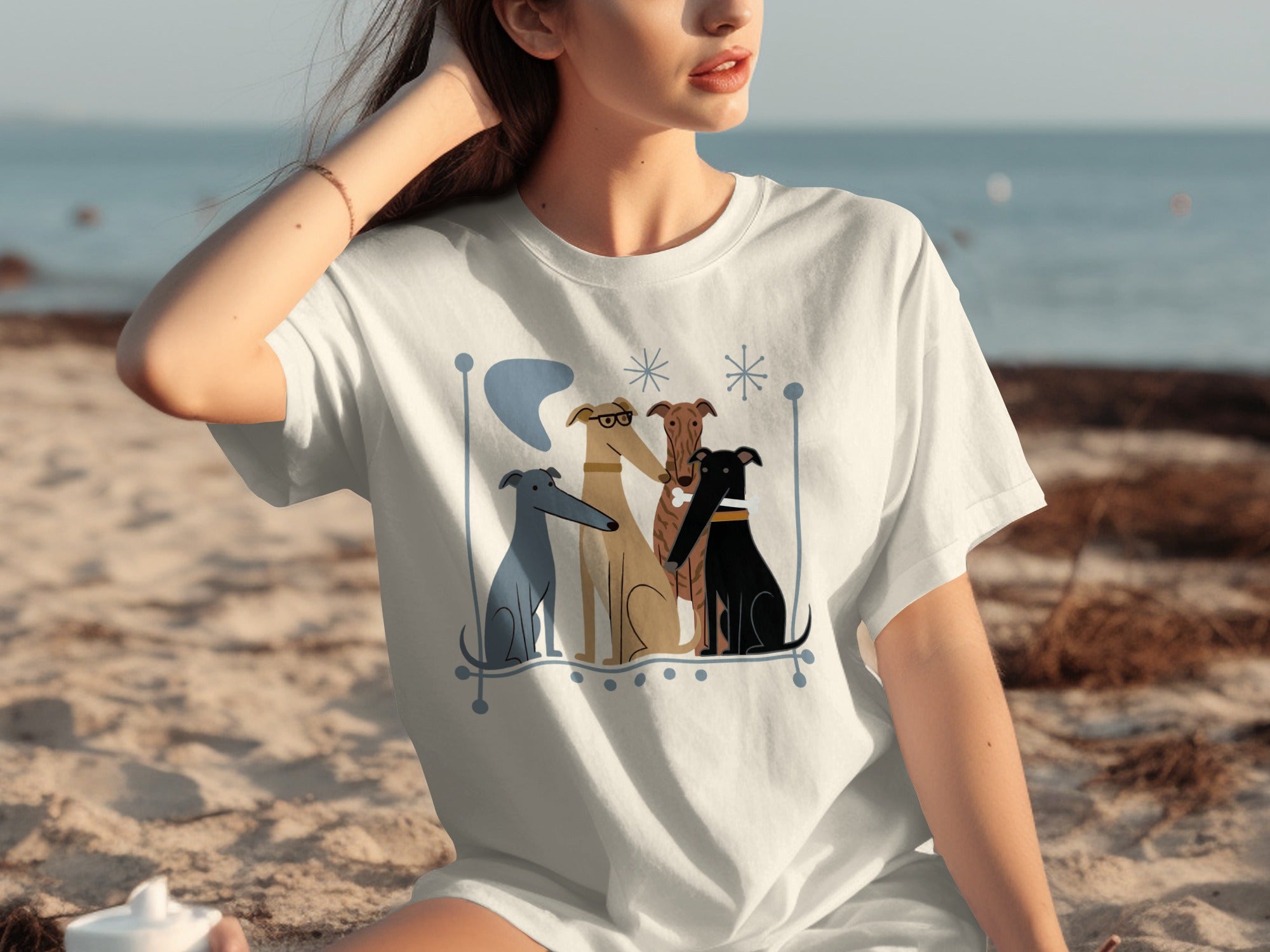 Four dogs of different colors and breeds sit together on a white t-shirt.