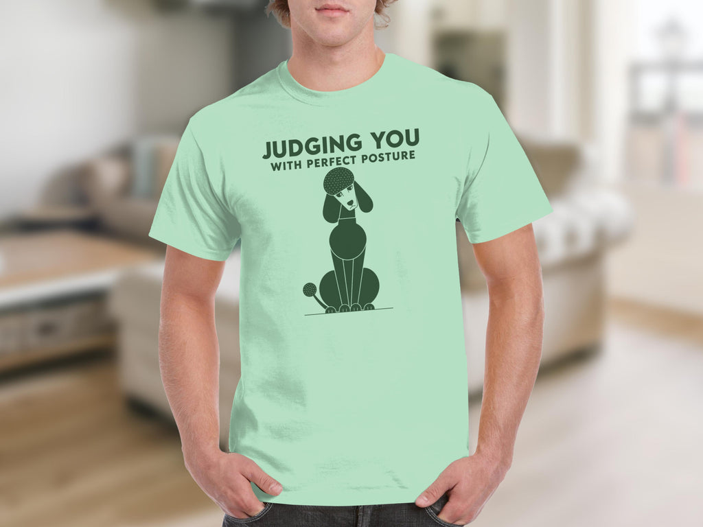 Light green t-shirt with a poodle illustration and the text "JUDGING YOU WITH PERFECT POSTURE".