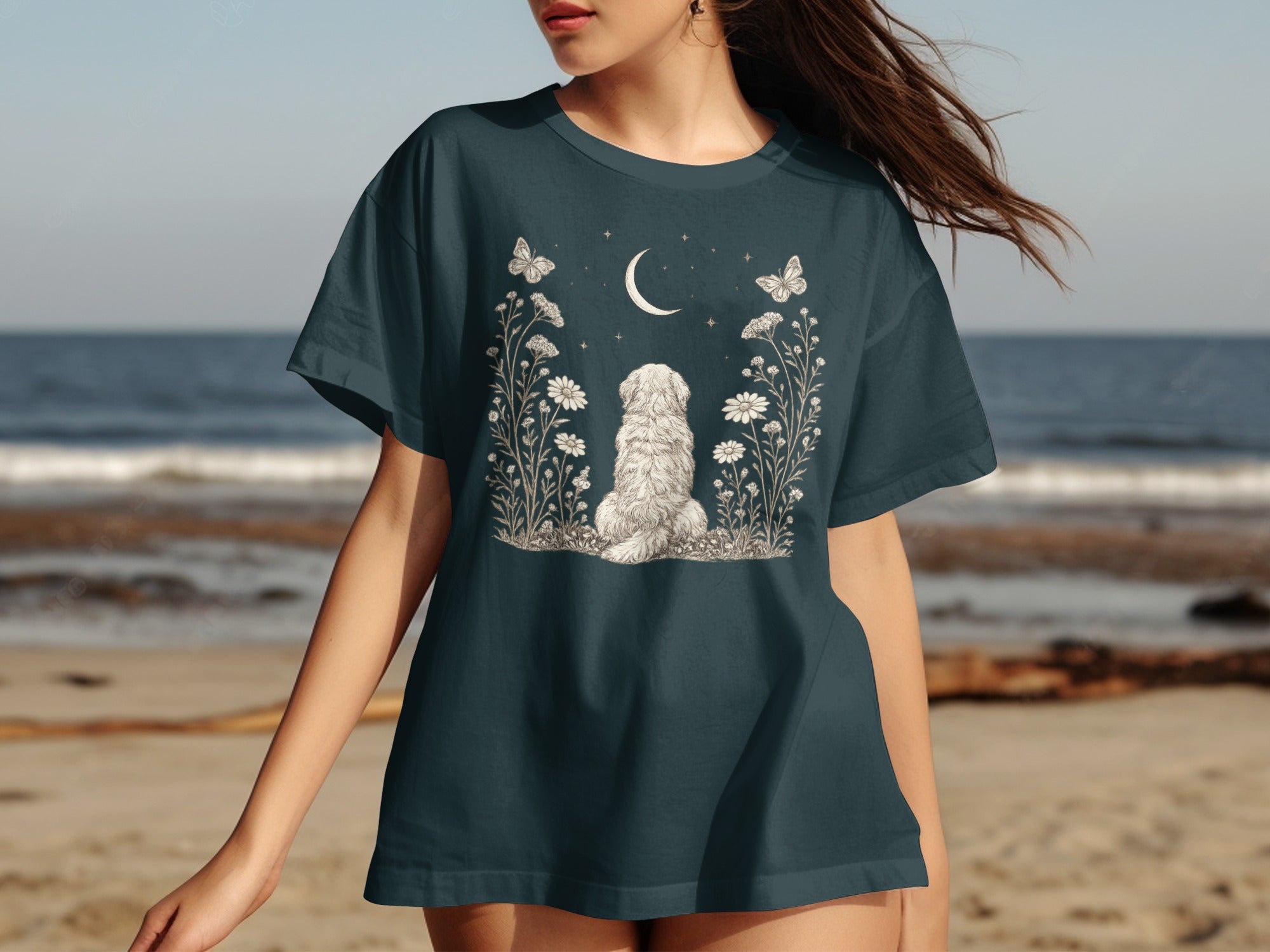 Dark teal t-shirt with illustration of white poodle, flowers, butterflies, and crescent moon.
