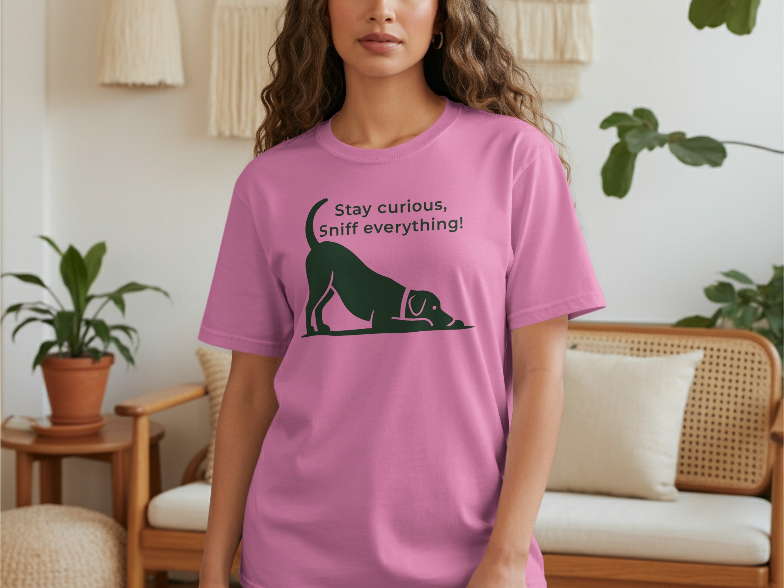 Pink t-shirt with a black dog silhouette and text "Stay curious, Sniff everything!".