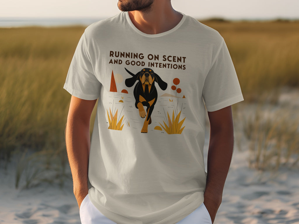 T-shirt with a graphic of a black and tan dog running through grass, text reads "RUNNING ON SCENT AND GOOD INTENTIONS".